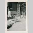 Girl standing by doorway of barracks (ddr-densho-329-1342)