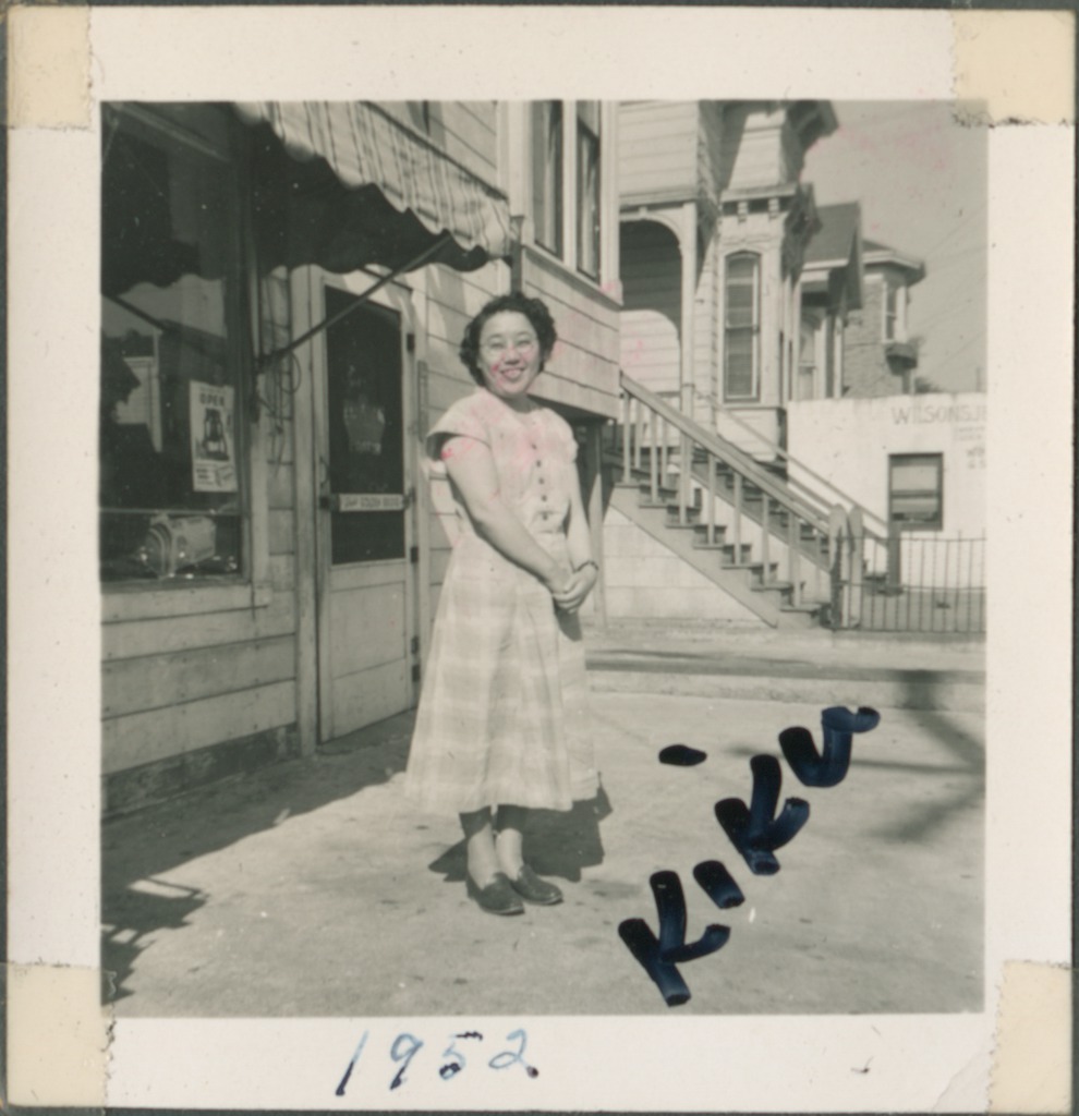 ddr-densho-321-111 — Woman standing near shop | Densho Digital Repository